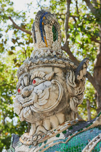 Close-up of angel statue against trees