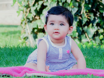 Portrait of cute girl sitting on field