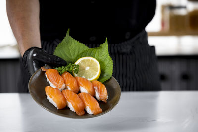 Midsection of man holding fruits on table