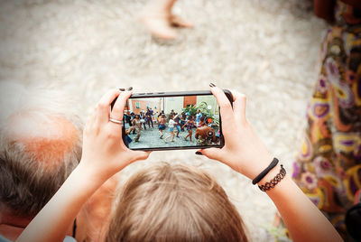 Midsection of woman photographing with mobile phone