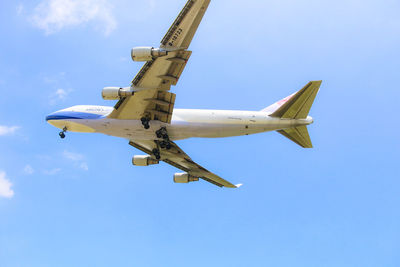 Low angle view of airplane against blue sky