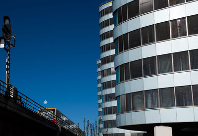 Low angle view of skyscraper against clear blue sky