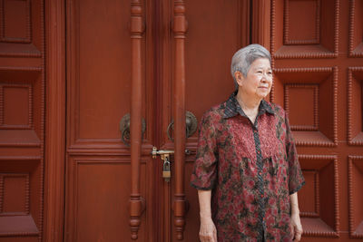 Full length of woman standing against door