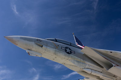 Low angle view of fighter airplane flying against blue sky