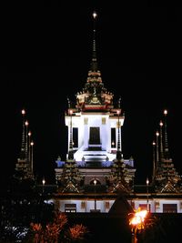 Illuminated temple against clear sky at night