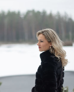 Portrait of young woman looking at winter