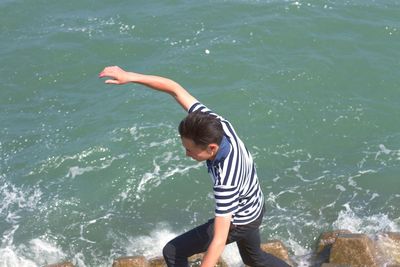 High angle view of boy standing in sea