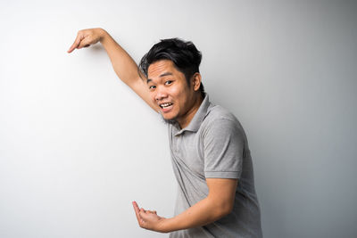 Smiling young man standing against white background