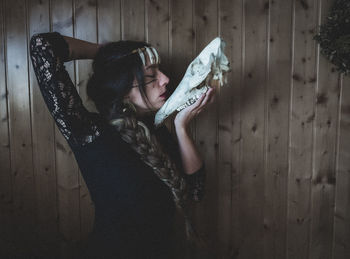 Rear view of woman standing against wall