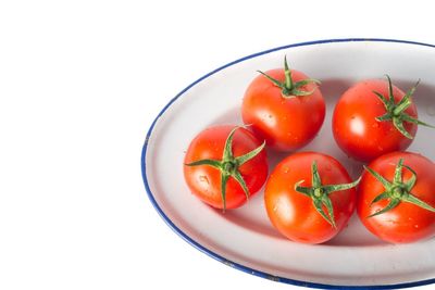 Close-up of tomatoes in bowl against white background