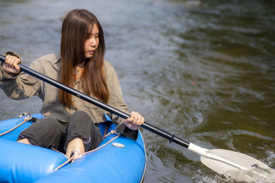 Young woman sitting on boat in river