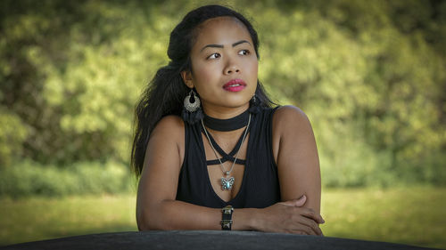 Portrait of young woman sitting outdoors