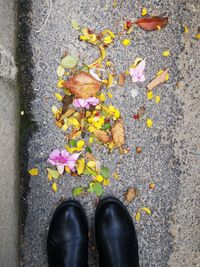 Low section of person with autumn leaves on street