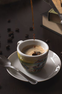Espresso being poured in cup on table