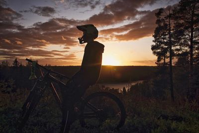 Silhouette of bicycle on field during sunset