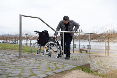 A physically disabled person in a wheelchair trying to go down the stairs