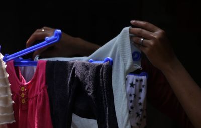 Cropped image of woman drying laundry on clothesline