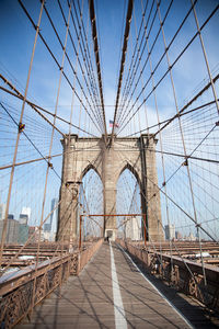 Low angle view of american flag on brooklyn bridge against sky