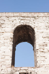 Low angle view of old ruin against clear blue sky