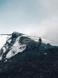 Man on snowcapped mountain against sky