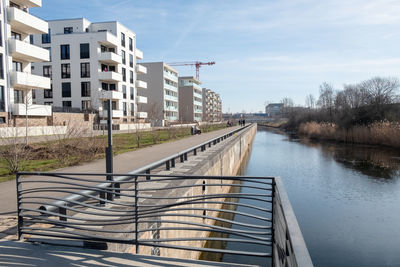 View of river by buildings against sky