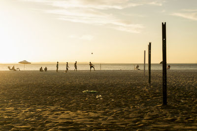 Young people playing beach soccer during sunset at ribeira beach in salvador, bahia, brazil.