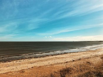 Scenic view of beach against blue sky