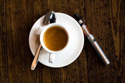 Directly above shot of coffee cup on wooden table