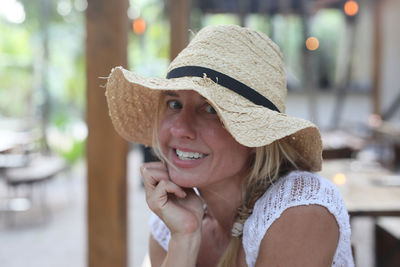 Close-up of smiling young woman wearing hat