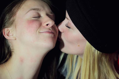 Close-up of lesbian couple kissing at home