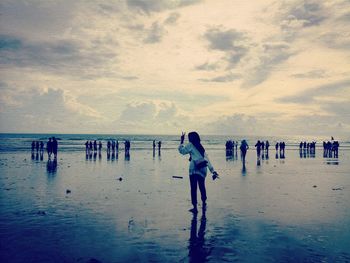 People at beach against sky