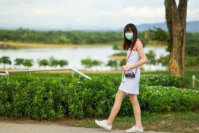 Portrait of woman standing by plants