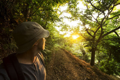 Male hiker looking back at forest during sunset