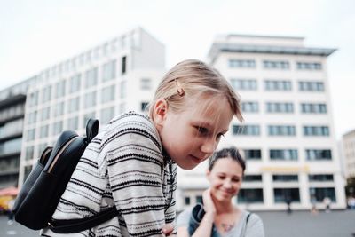 Portrait of mother and daughter in city