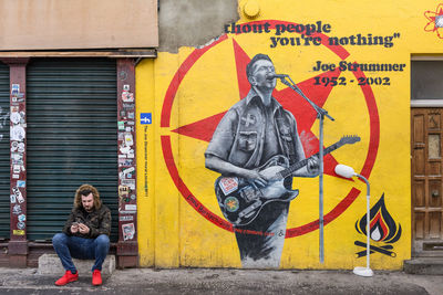 Full length of woman with graffiti on wall