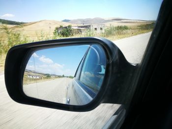 Reflection of road on side-view mirror of car