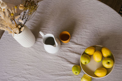 Still life of the dining table. dried flowers in a white ceramic vase, a jug and a clay cup 