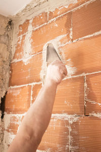 Cropped hand of man working at construction site