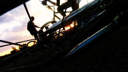 Close-up of bicycle wheel against sky during sunset