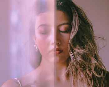 Close-up of woman with closed eyes by curtain