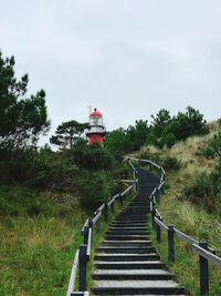 Staircase amidst trees against sky