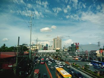 Traffic on road by buildings against sky