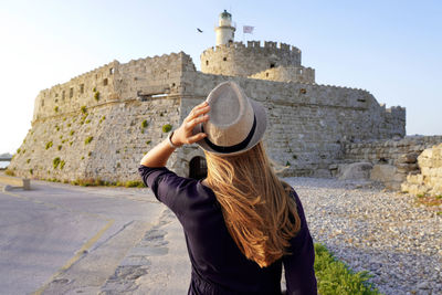 Holidays in greece. back view of beautiful girl in rhodes city, unesco world heritage site.