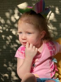 Close-up of cute girl sitting out outdoors