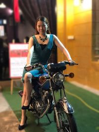 Full length of young woman riding motorcycle