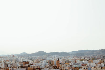 Buildings in city against clear sky