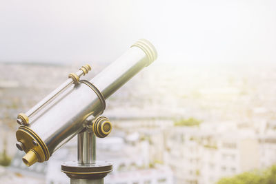 Close-up of hand-held telescope against cityscape