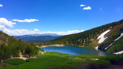 Scenic view of lake and mountains against blue sky