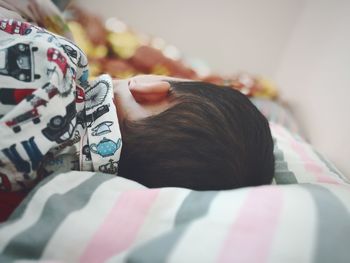 Close-up of child sleeping on bed at home