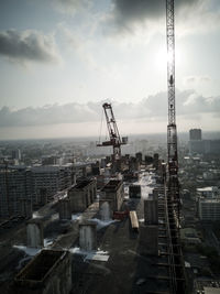 High angle view of crane and buildings against sky